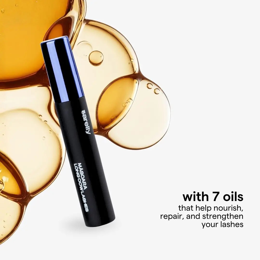 A black and blue tube of mascara cow  Lashes is shown against a white background with decorative golden oil droplets and text that reads 'with 7 oils that help nourish, repair, and strengthen your lashes'.
