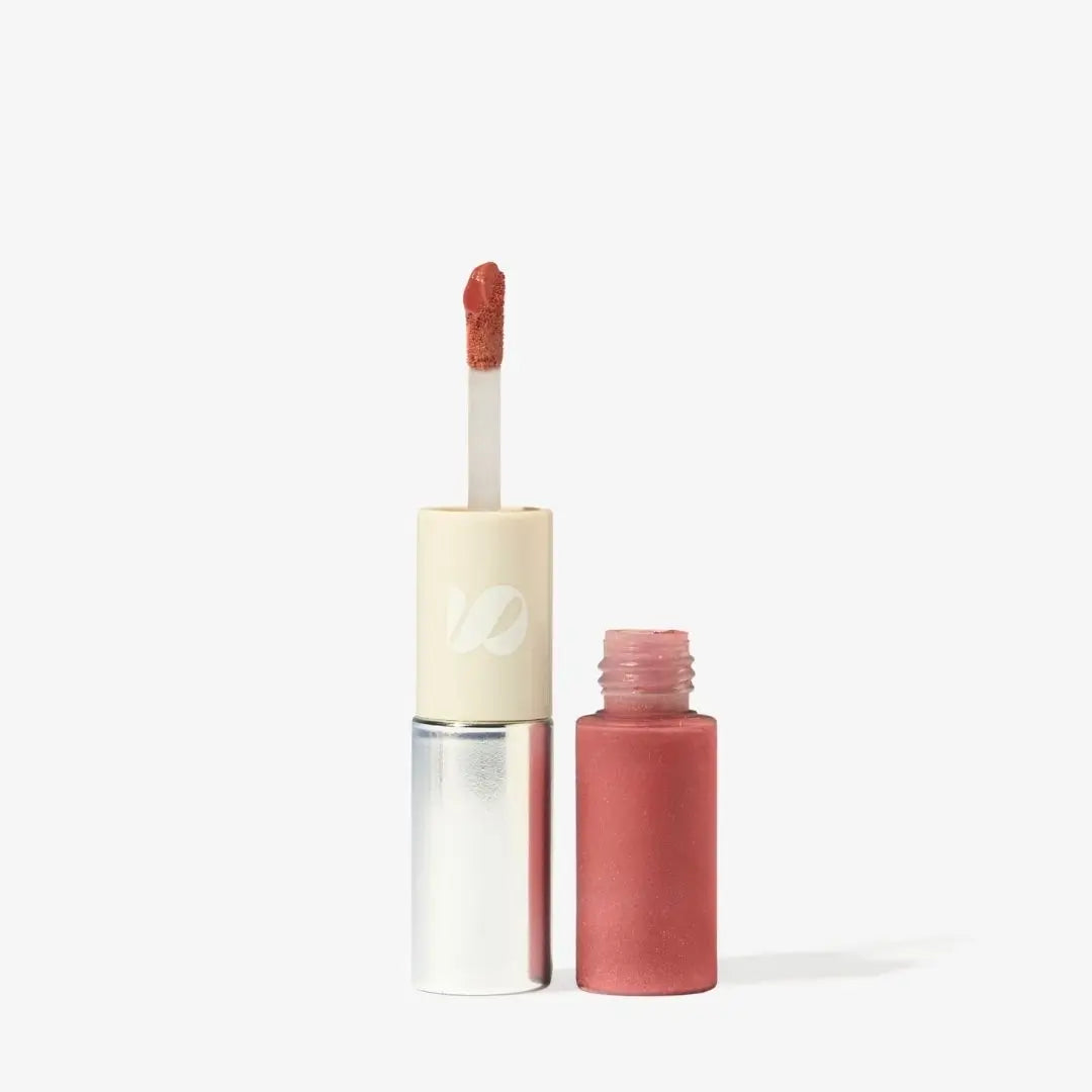 A liquid lipstick and lip gloss bottle with its applicator wand shown beside the open bottle, on a clean white background. The product color is a muted dusty rose pink, with a cream-colored cap and a silver metallic lower section. Shade Florencia